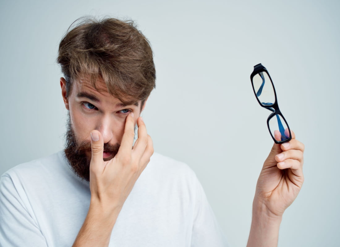 man wiping his eye due to excessive tearing