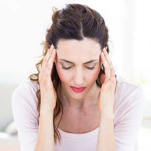 woman with a headache holding her head