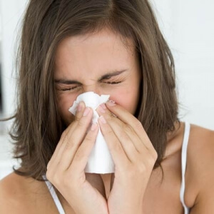 Woman blowing her nose