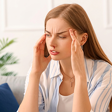 Woman experiencing epistaxis